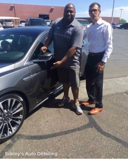 Gray vehicle being presented at a dealership